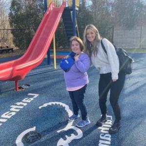 Staff at Latham Centers welcomes new student on her first day and shows her the Latham campus playground.